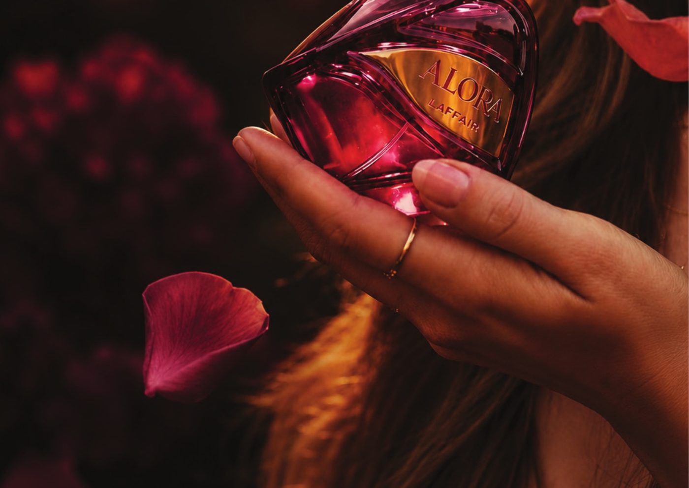 Alora bottle held among rose petals