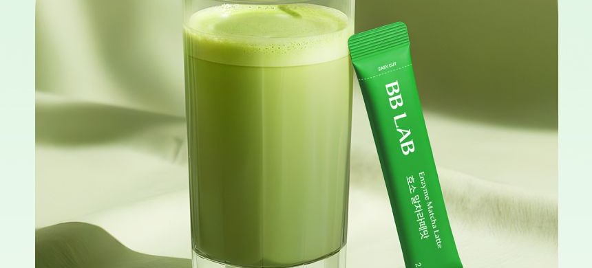 Matcha latte in a glass with a stick beside it