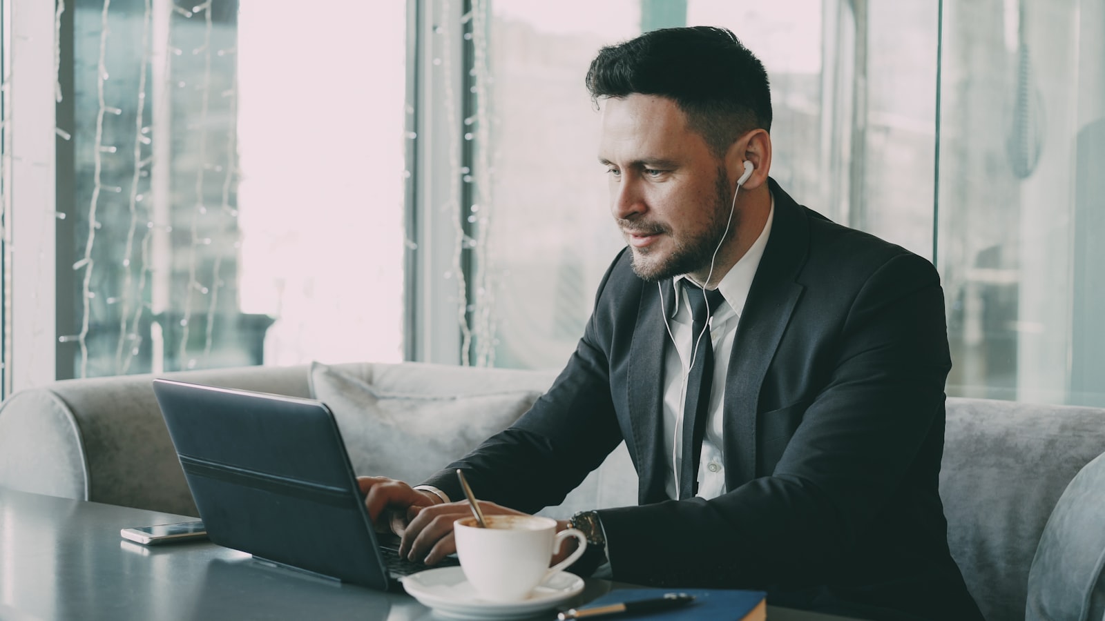 A person working thoughtfully on a laptop at a desk