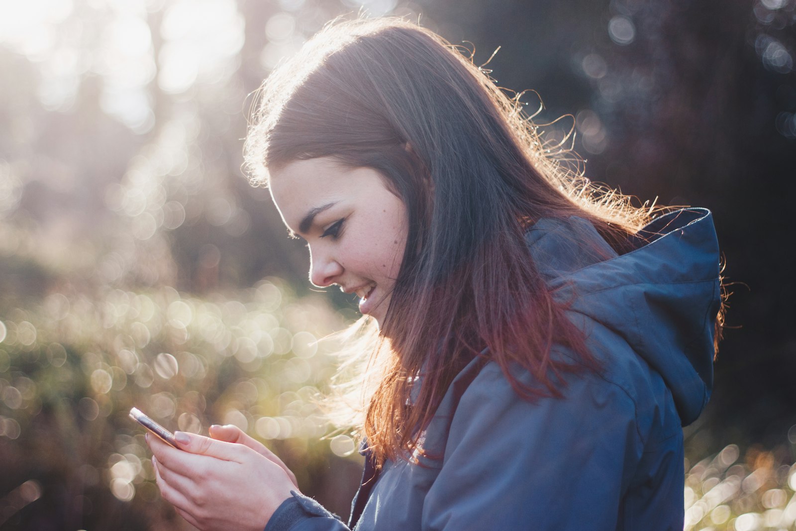 A creator smiling while working on their phone