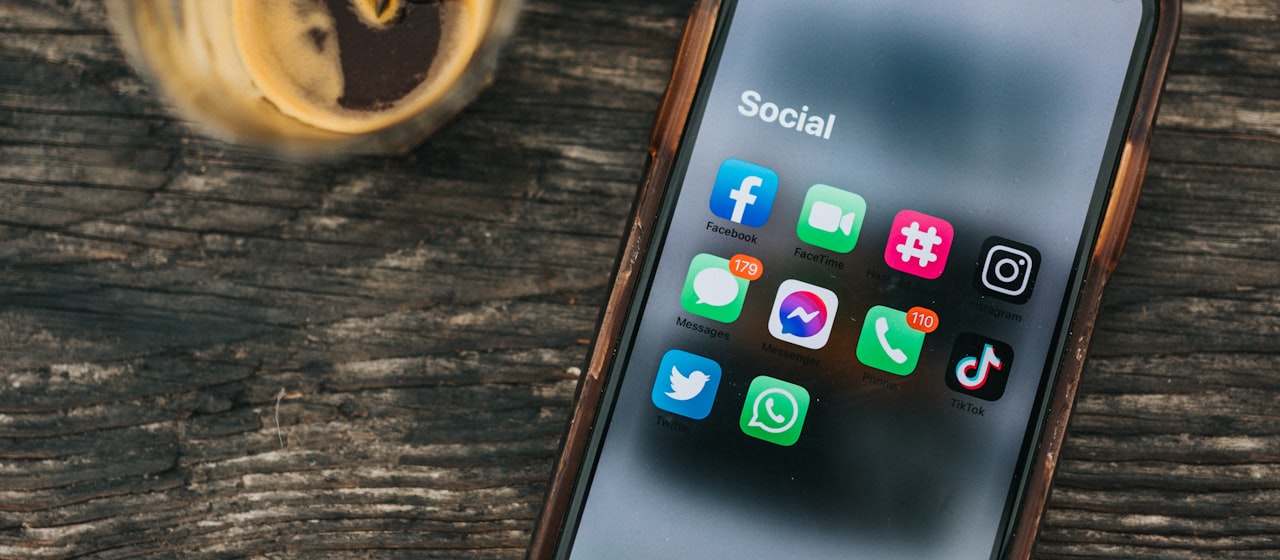 A phone showing social media apps including TikTok and Instagram
