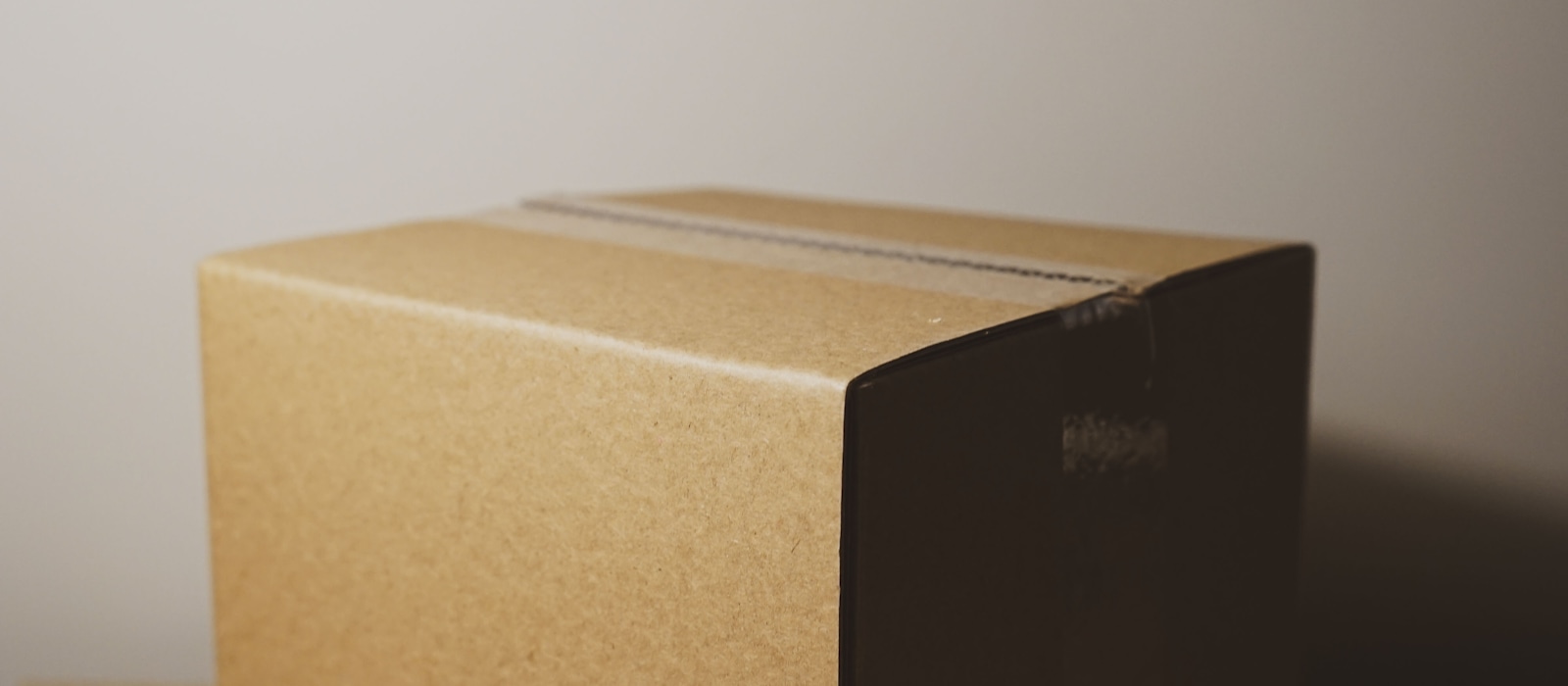 A sealed cardboard shipping box on a plain background